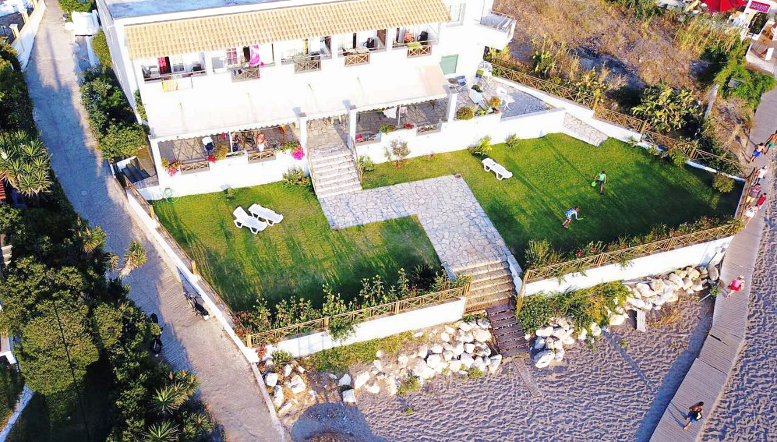 Ein modernes Gebäude mit Innenhof, Außenbestuhlung und Poolbereich.