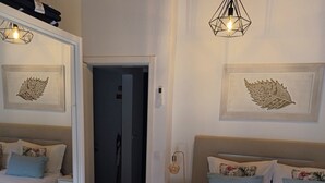Een slaapkamer met twee bedden, een houten vloer en een gang naar een andere kamer.
