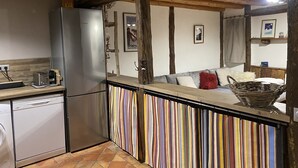 Una cocina con salpicadero a rayas, vigas de madera, un refrigerador y un lavavajillas.