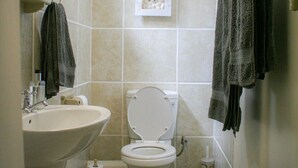 Ein Badezimmer mit Waschbecken, Toilette und Handtuchhalter.