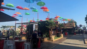 An outdoor seating area with tables and chairs, umbrellas hanging overhead, and a building in the background. - Room-quiet Single Bedroom in the Centre (Zagreb)