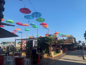 An outdoor seating area with tables and chairs, umbrellas hanging overhead, and a building in the background. - Room-quiet Single Bedroom in the Centre (Zagreb)