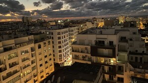 Un paisaje urbano al atardecer, con edificios y un ocaso.