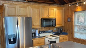 A kitchen with wooden cabinets, stainless steel appliances, and a large island with a sink.