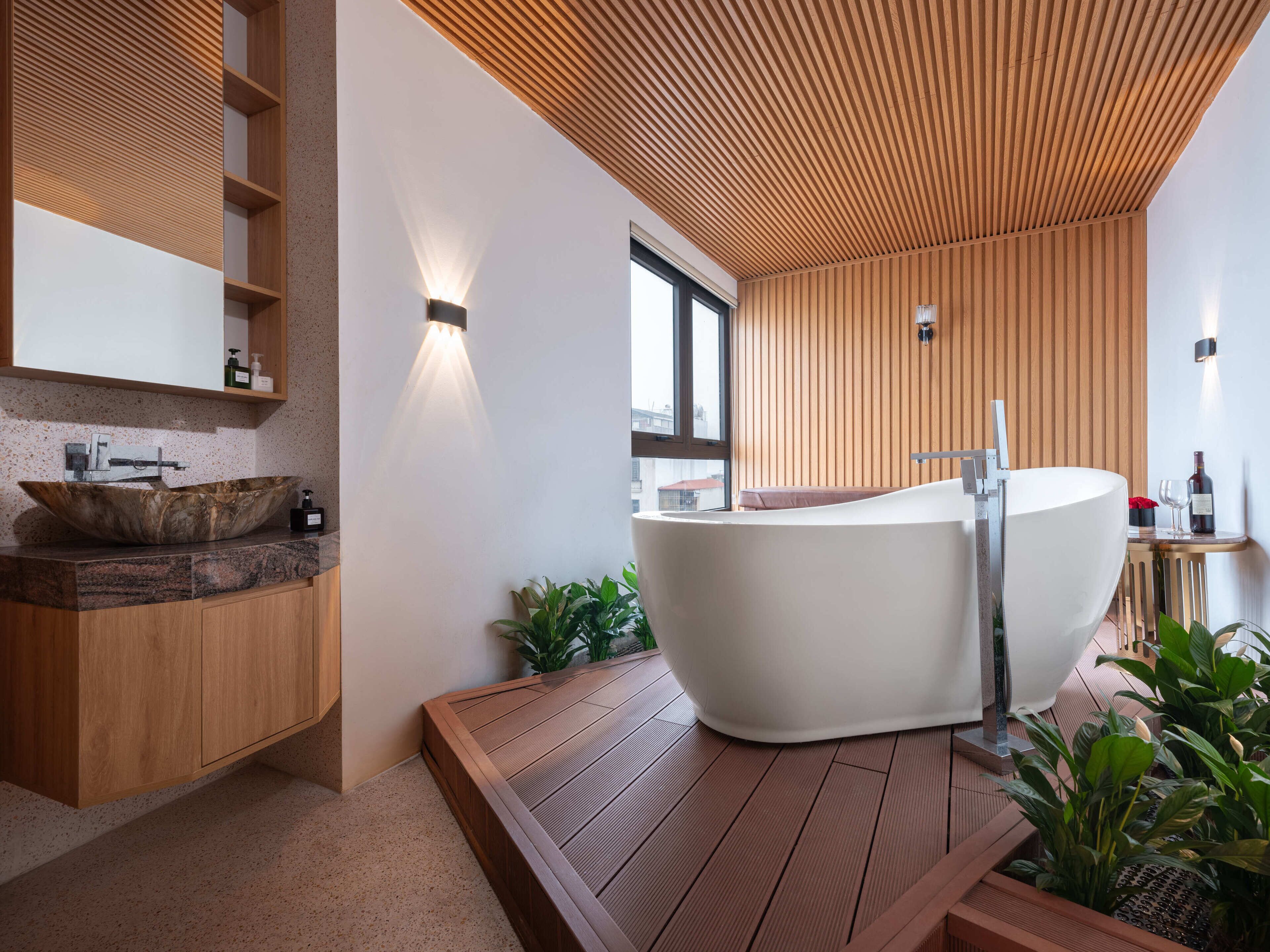 A modern bathroom with a freestanding bathtub, wooden paneling, and a large window.