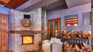 Una chimenea de piedra con espacio para leña y una acogedora disposición de asientos.