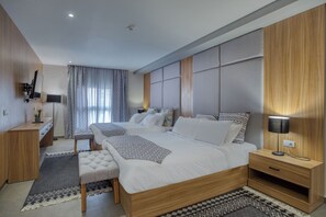 Une chambre d’hôtel moderne, dotée d’un grand lit, d’un bureau et d’une table de chevet.