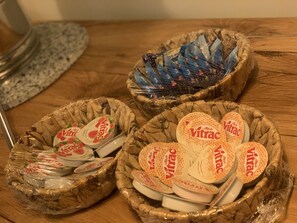 Trois paniers en osier contenant des pots de yaourt, posés sur une surface en bois.