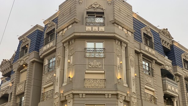 A multi-story building with ornate architectural details, including decorative moldings and balconies with wrought iron railings. - Locanda Museum Hotel (Giza)