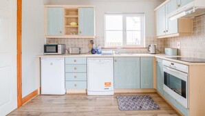 A compact kitchen with a microwave, toaster, and dishwasher. - Summercove 04 - Family Estate (Lahinch)