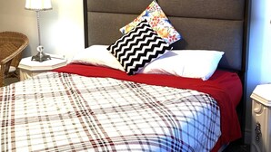 A bed with a plaid bedspread, a red blanket, and multiple pillows including a floral one. - Niagara Sleeps 6 Cozy 3bed 3bath Near Falls (Thorold)