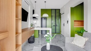 Una cocina moderna con estufa integrada, un lavamanos y una pared de acento verde.