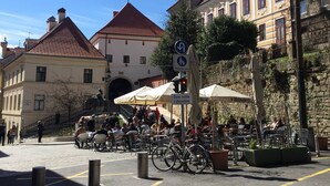 Une place publique dotée d’un espace extérieur aménagé avec des sièges, des vélos et entourée de bâtiments historiques.