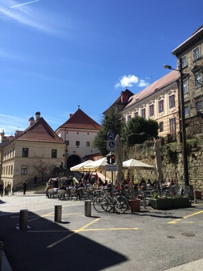 Une place publique dotée d’un espace extérieur aménagé avec des sièges, des vélos et entourée de bâtiments historiques.