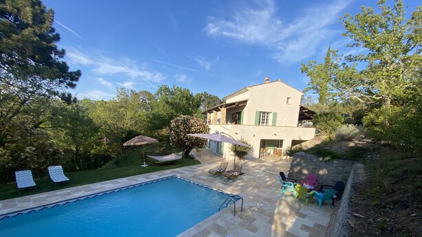 A pool area with lounge chairs, a hammock, and a stone wall. - 8-person villa in quiet location near lake and beach (Saint-Paul-en-Forêt)