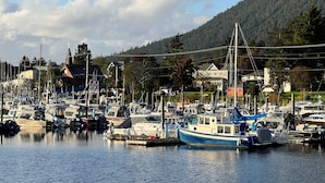 A marina with boats docked, a church, and houses in the background.