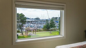 A room with a large window overlooking a marina with boats and a gazebo.