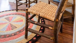 A staircase with wooden railings and a woven chair in the foreground.