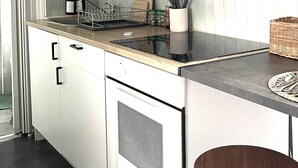 Eine moderne Küche mit weißen Schränken, einer schwarzen Arbeitsplatte und einer Edelstahl-Dunstabzugshaube.