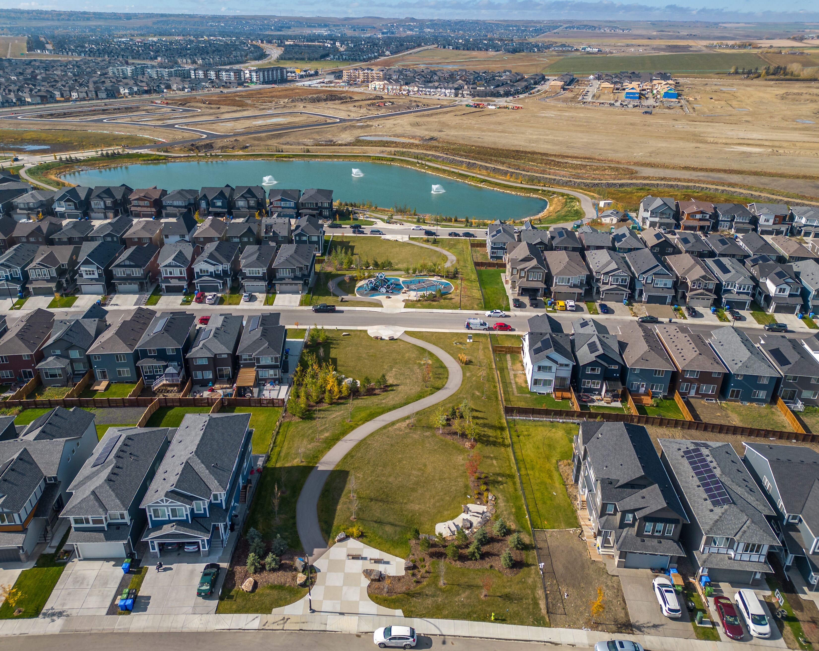 A residential area with multiple houses, a swimming pool, and a road.
