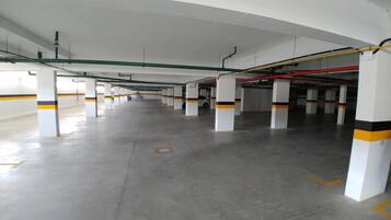 A multi-level parking garage with white pillars and yellow stripes, featuring a clean, organized layout.