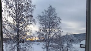 A snowy landscape with bare trees and a small cabin. - Forest Family Home (Ytterhogdal)