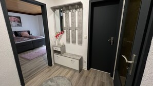 Ein Schlafzimmer mit Bett, Kommode, Spiegel und Tür.