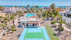 A residential area with a basketball court, palm trees, and a view of the sea. - Modern Luxury Beachside Retreat (Puerto Peñasco)