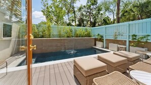 A private outdoor pool area with a wooden deck, lounge chairs, and a glass door entrance. - Home With Private Pool 'The Blue Lagoon' (Charleston)
