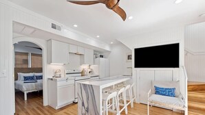 A compact kitchen with white cabinetry, a marble island, and a ceiling fan. - Home With Private Pool 'The Blue Lagoon' (Charleston)