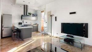 A modern kitchen with a central island, a built-in microwave, and a stainless steel range hood. - 051 Living apartment within walking distance of downtown and FS station (Bologna)