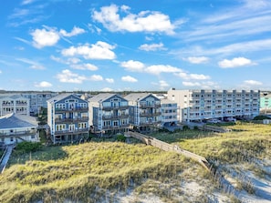 A beachfront residential area with multi-story buildings, some with balconies, and a sandy beach in the foreground. - Saagara Thira (Carolina Beach)
