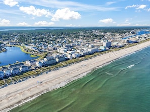 An aerial view of a coastal city with a beachfront hotel area, including buildings and a beach. - Saagara Thira (Carolina Beach)
