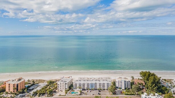 A coastal hotel with multiple buildings, a beach, and a clear sky. - Oceanfront Serene 2-bedroom 2 bath in Indian Shores Florida. (Indian Shores)