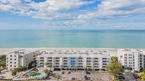 A hotel with multiple floors, a swimming pool, and a view of the beach and ocean. - Oceanfront Serene 2-bedroom 2 bath in Indian Shores Florida. (Indian Shores)