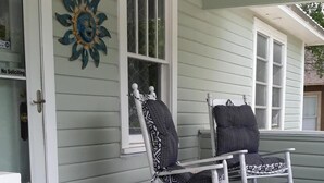 A porch with two rocking chairs, a decorative sunburst wall art, and a doormat with 'grateful thankful blessed' text. - Cozy Private Home @ Blue Moon Cottage in Historic Deland, Fl. (DeLand)