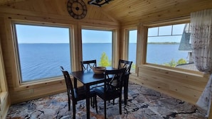 A wooden cabin with a table and chairs, large windows, and a view of the water. - LoZa House rooftop SkyDeck lakefront  Pets Hot Tub (Plattsburgh)