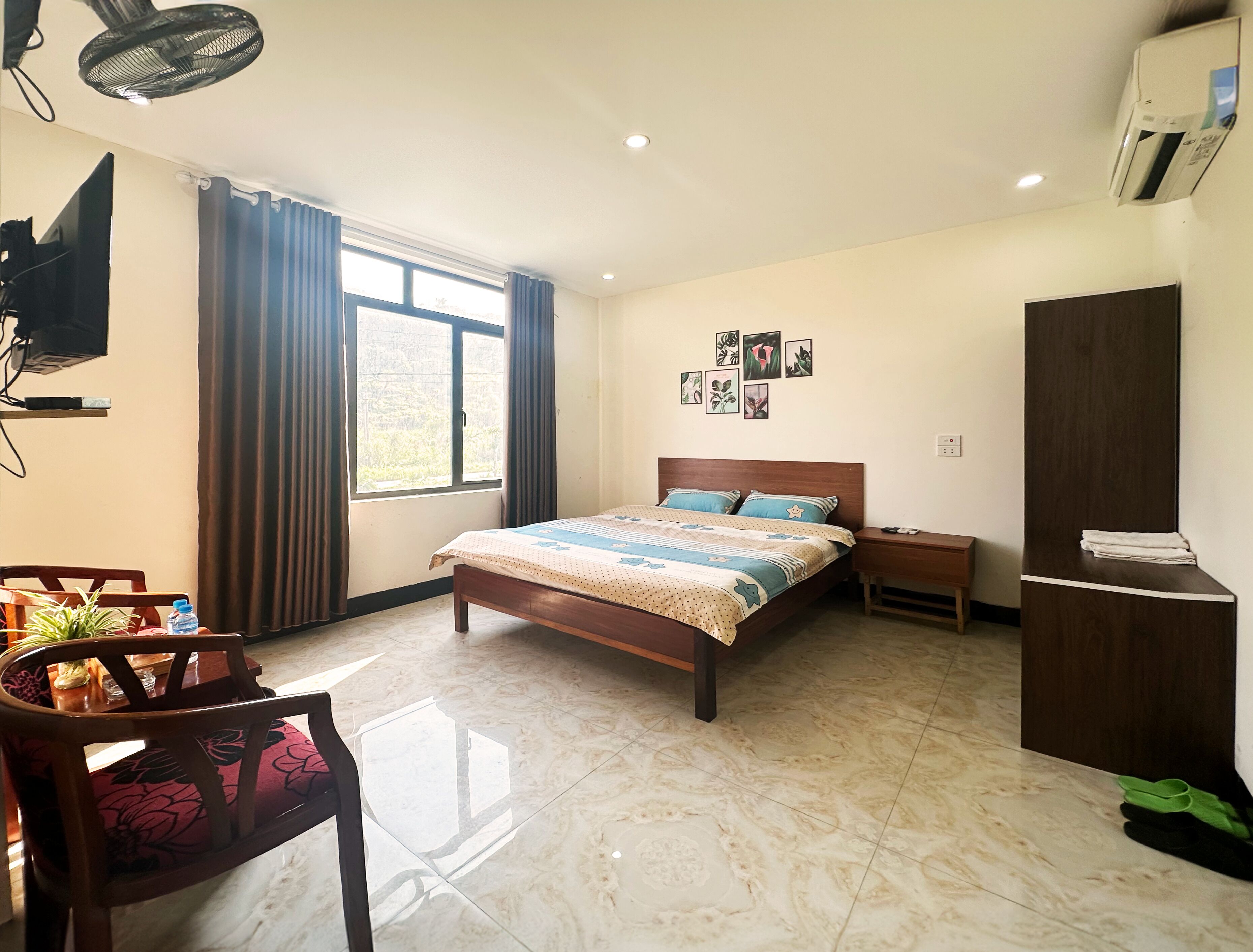 A bedroom with a bed, a desk, a chair, a wardrobe, and a window with curtains.