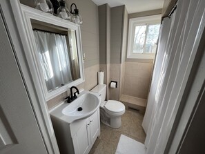 Ein Badezimmer mit Waschbecken, Toilette und Duschbereich.