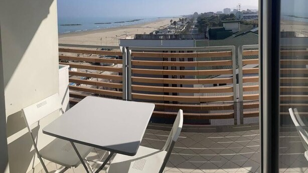 A balcony with a view of a beach and cityscape. - APARTMENT BY THE SEA (Roseto degli Abruzzi)