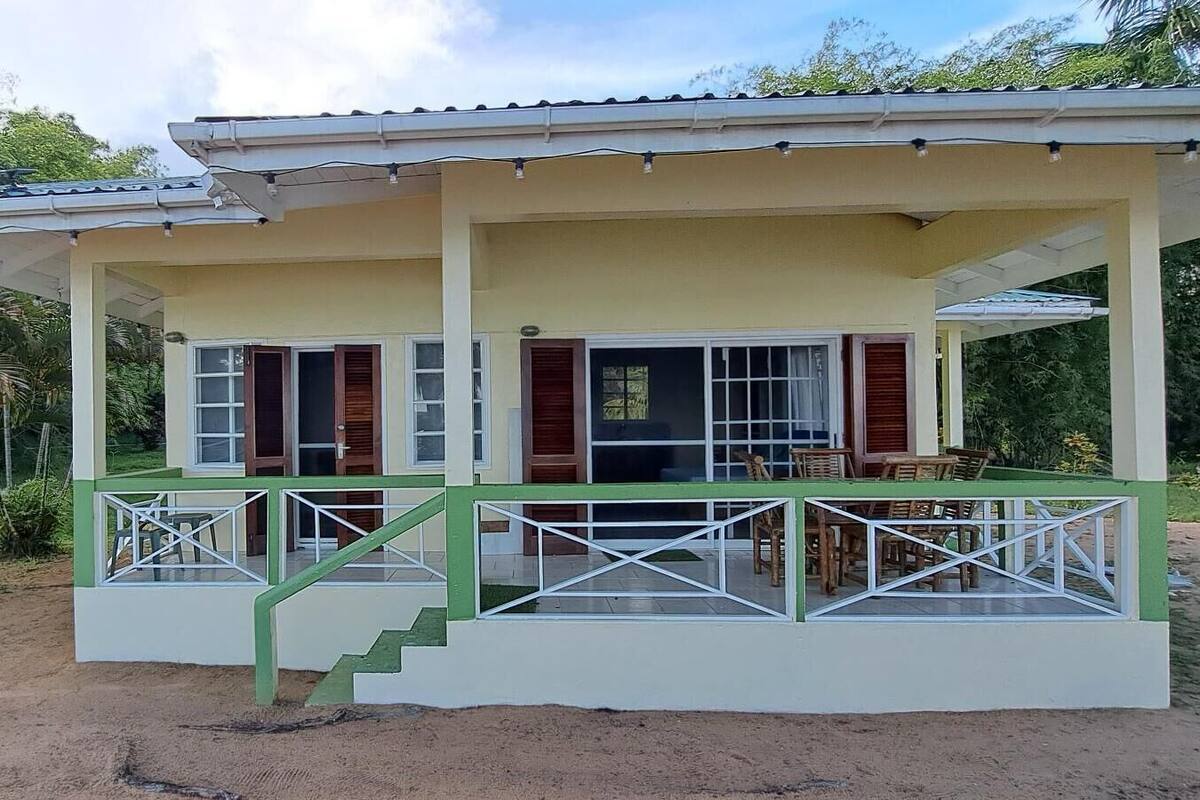 A two-story house with a covered porch and a staircase leading to the upper floor.