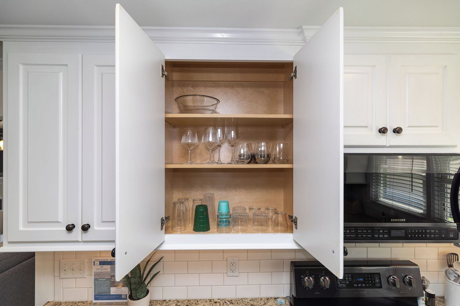 A kitchen with white cabinets, a microwave, and a stove.