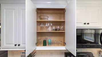 A kitchen with white cabinets, a microwave, and a stove.