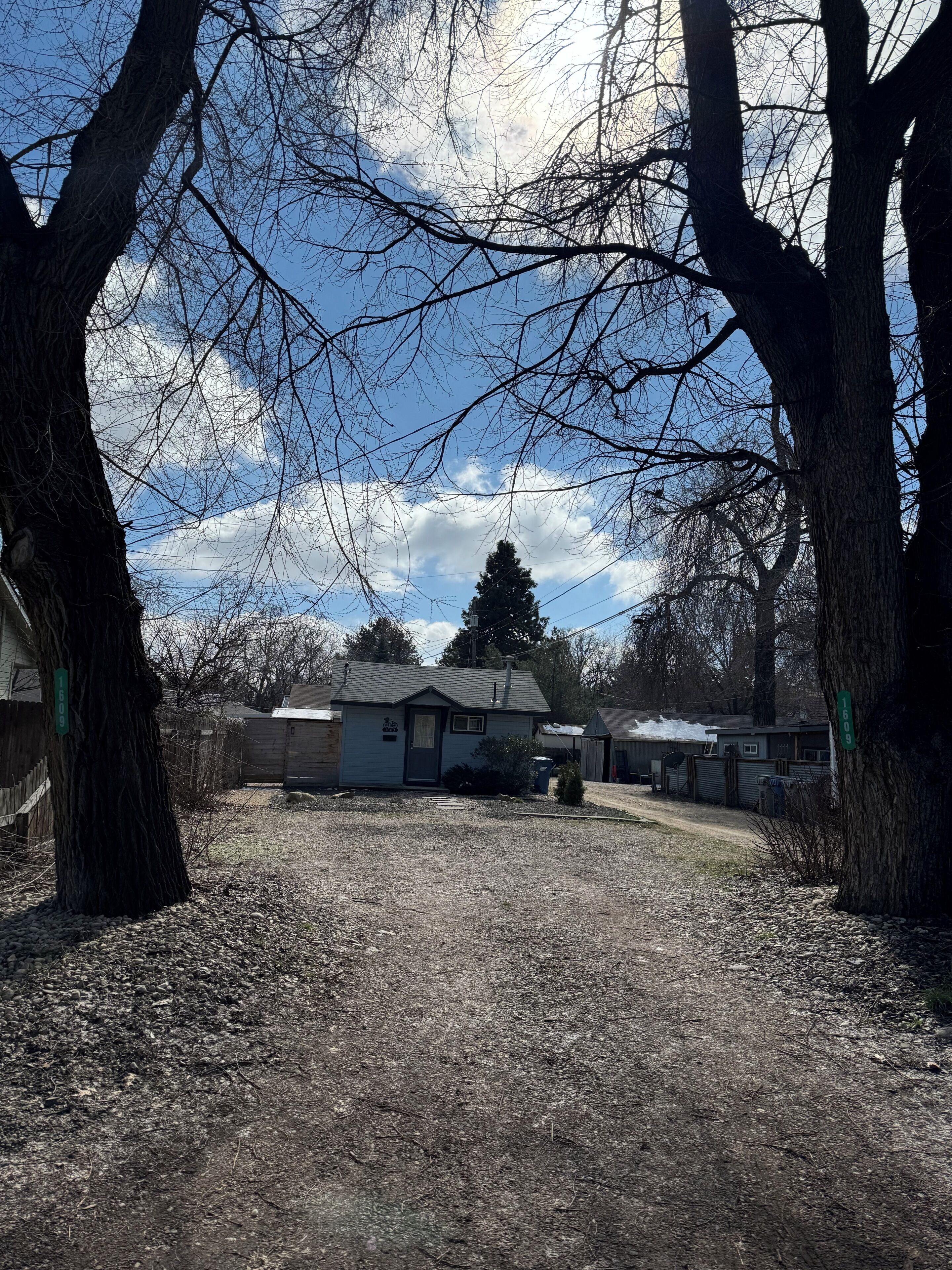 A residential area with a house, trees, and a clear sky.