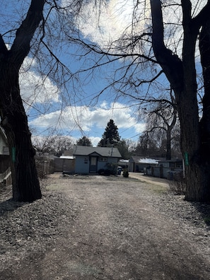 A residential area with a house, trees, and a clear sky.