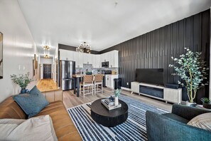 Una sala de estar moderna con un sofá, una mesa de centro y un televisor.
