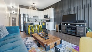 A modern living room with a sofa, coffee table, and a TV stand.