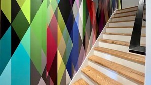 A staircase with wooden steps and a colorful geometric wall design.