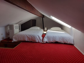 A room with two beds, a red patterned carpet, a white air conditioning unit, and a skylight. - Right in the heart of Cannes, a 5-minute walk from the Palais and the beach. (Cannes)