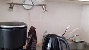 A kitchen with a coffee maker, a kettle, and a bag of coffee.